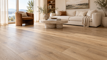 Oakel City bright living room with light wood-look vinyl plank flooring, a cream sofa and a round stone coffee table.